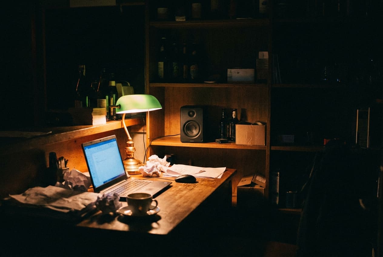 Backoffice einer Bar bei Nacht: Laptop, Papiere, Lautsprecher im Regal